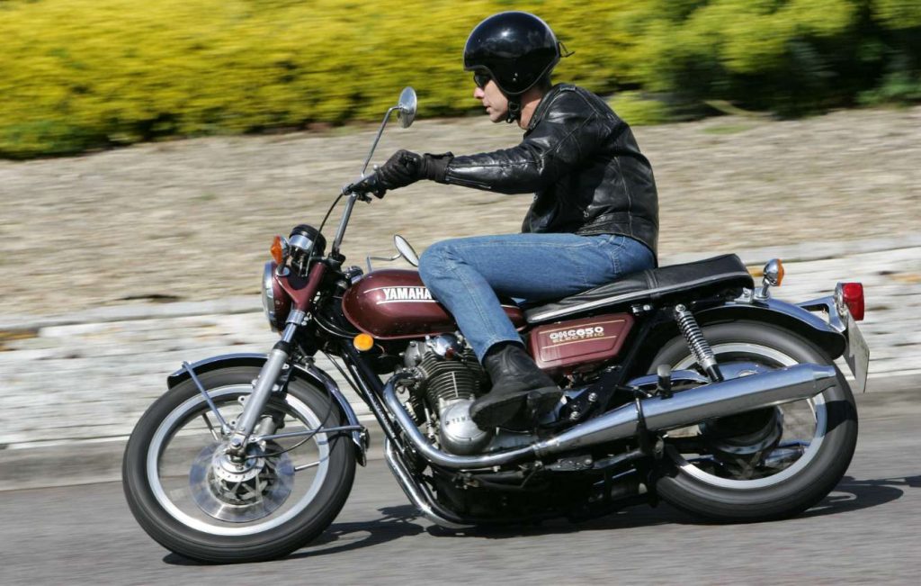 Man riding a metallic brown classic Yamaha motorbike
