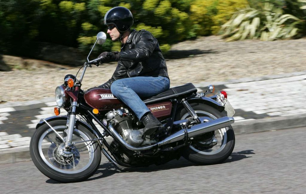 Man riding a metallic brown classic Yamaha motorbike