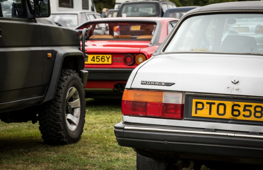 Rear view of several classic cars parked at an eventv