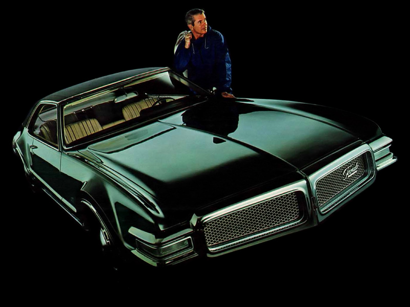 Man standing next to green Oldmobile Toronado