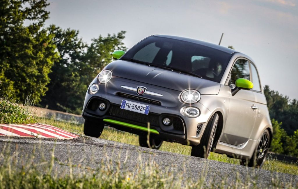 Grey 2019 Abarth 595 Pista with green colour kit driving around bend in road