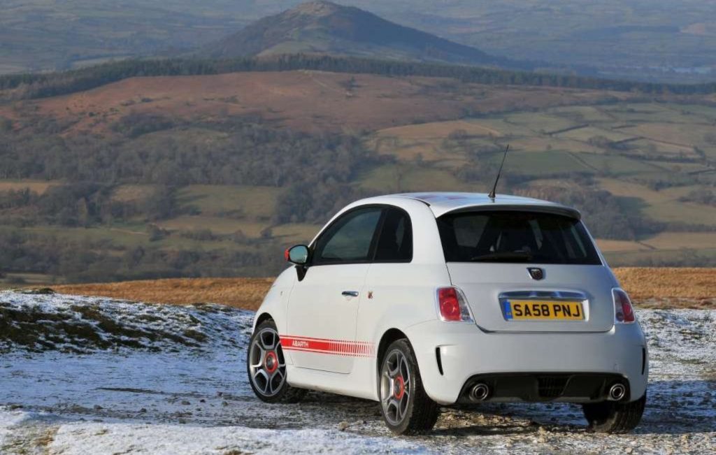 Rear view of a Campovolo Grey 2008 Abarth 500 parked on a hillside