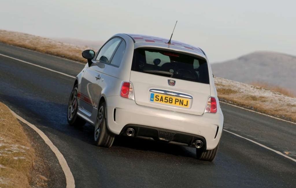 Rear view of a Campovolo Grey 2008 Abarth 500 driving along a road