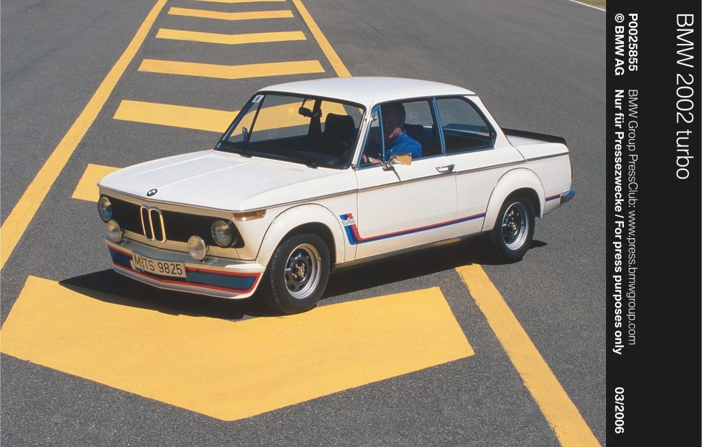 White BMW 02 Series parked on a road with yellow markings