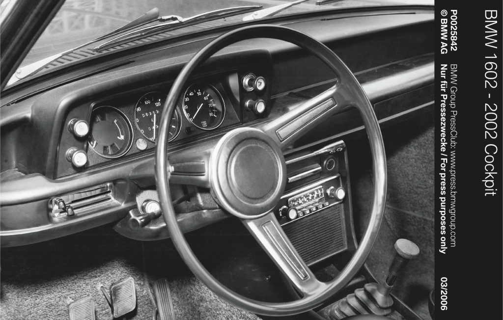 Greyscale of a BMW 02 Series steering wheel and dashboard