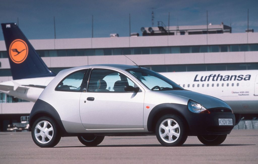 Silver Ford Ka parked in front of a plane with Lufthansa livery