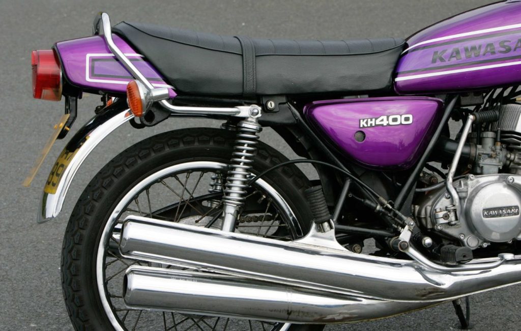 Exhaust pipe and rear wheel of a metallic purple motorbike