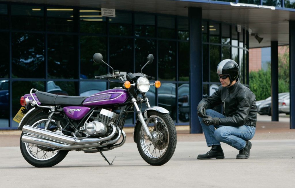 Rider sat next to a Candy Purple classic Kawasaki KH400