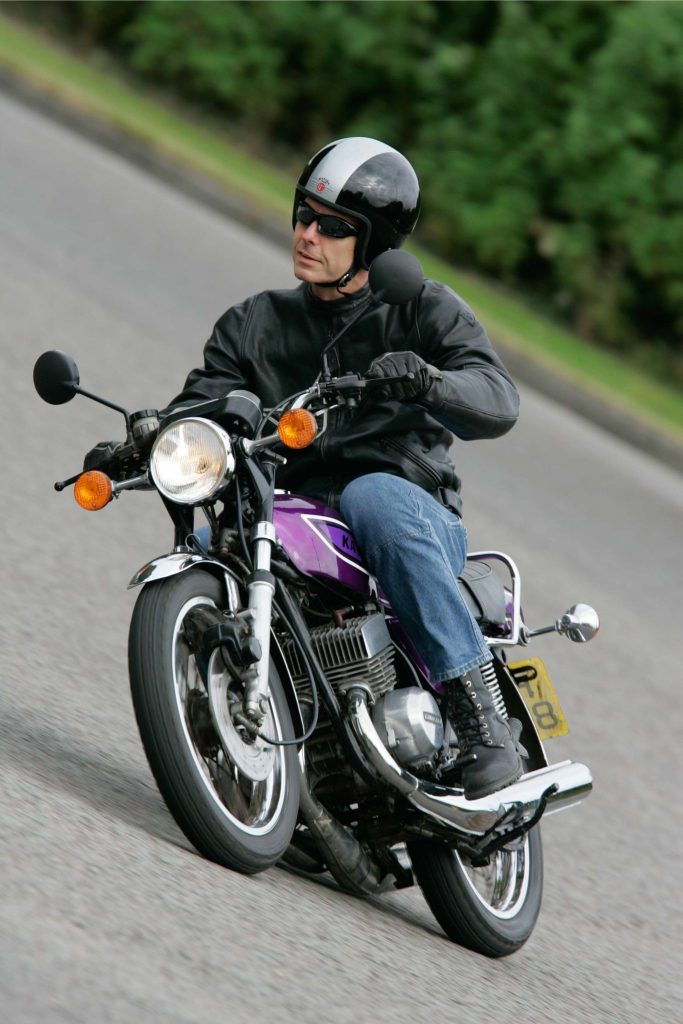 Front view of a man riding a classic motorbike