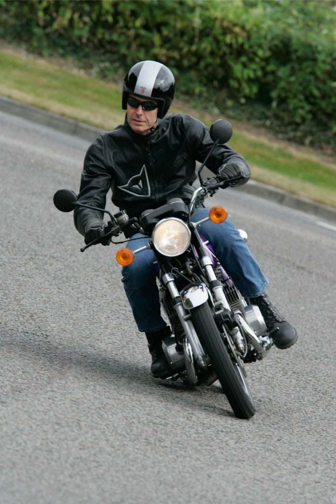 Front view of a man riding a classic motorbike