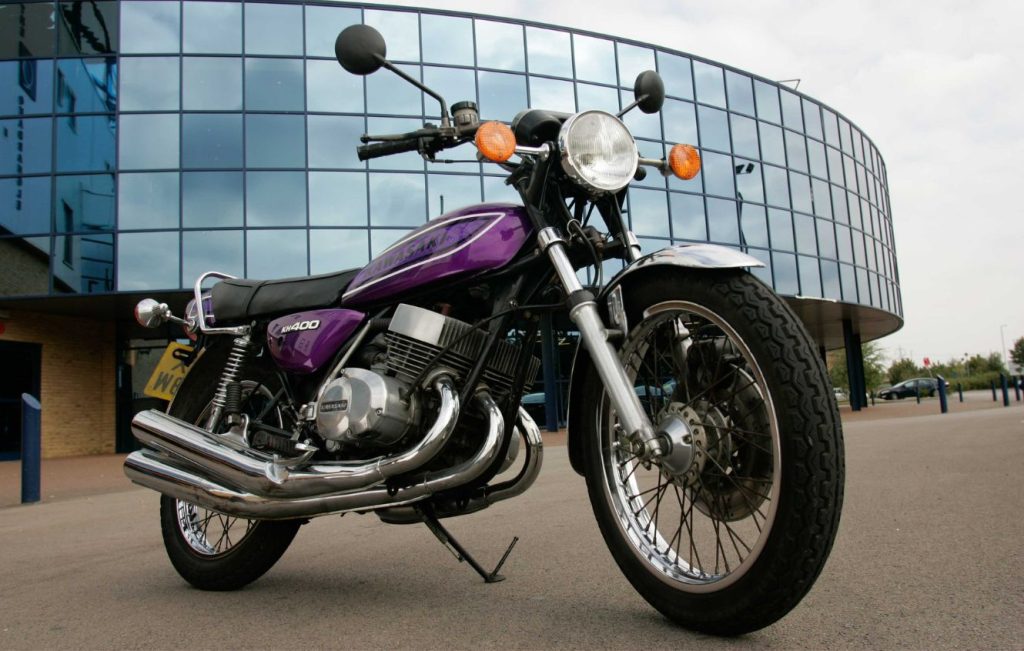 Classic motorbike parked in front of a glass building