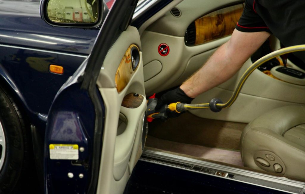 Man cleaning the interior of a car