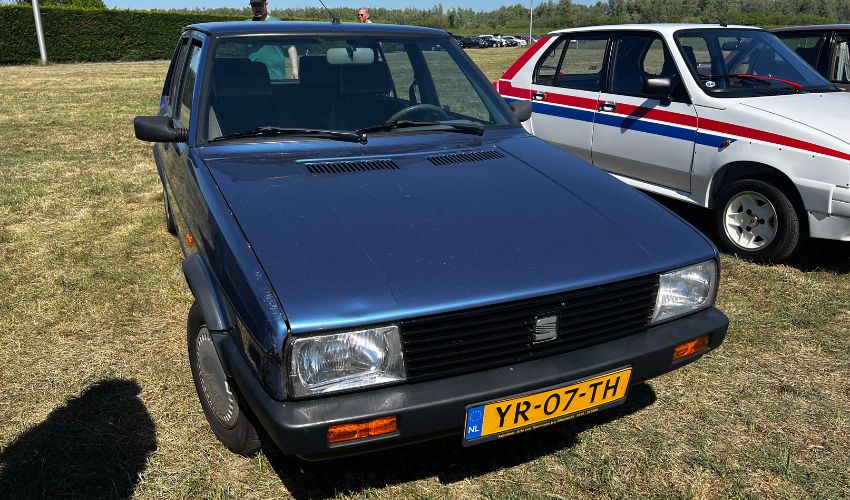 Metallic blue SEAT Malaga parked in a field at a car show