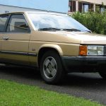 Gold Tagora V6 reverse parked in a driveway in front of a house