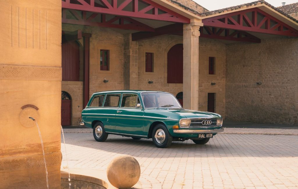 Turquoise Audi 80 estate parked in front of a stone building