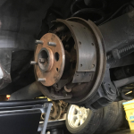 A drum brake assembly on a vehicle, likely a vintage model, in the process of being serviced.