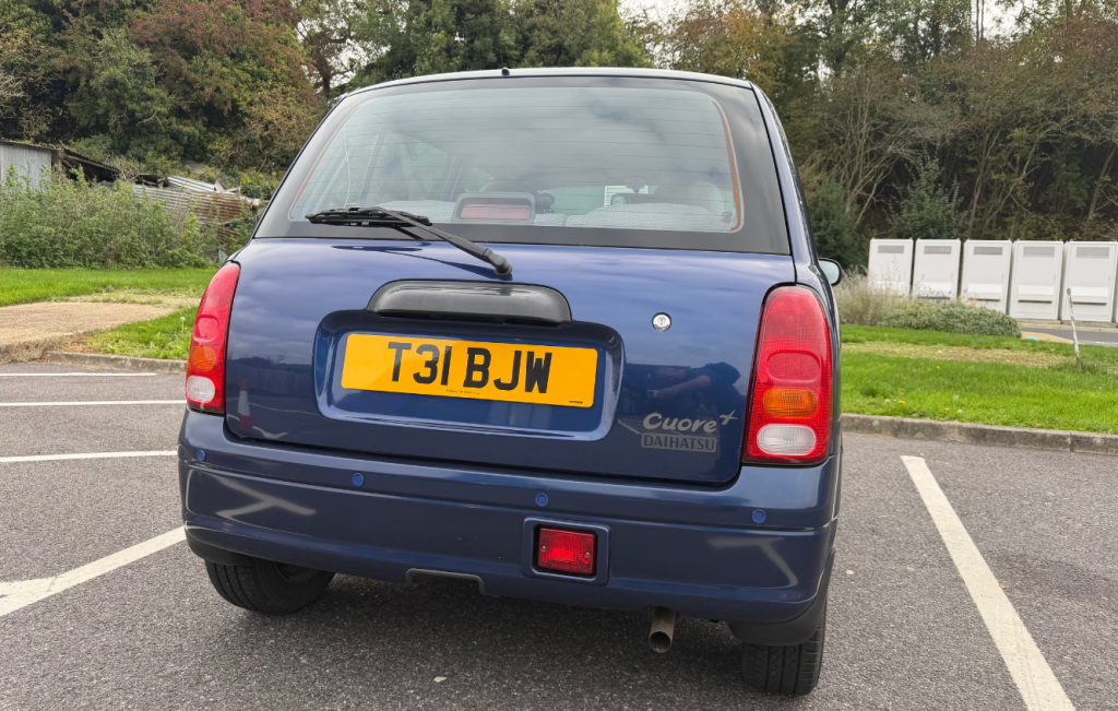 Dark metallic blue Daihatsu Cuore parked in a car park