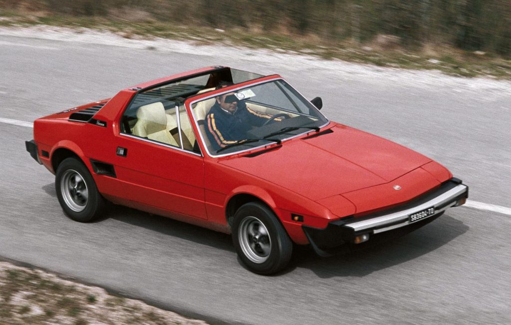 Man driving a red Fiat X1_9 long a road