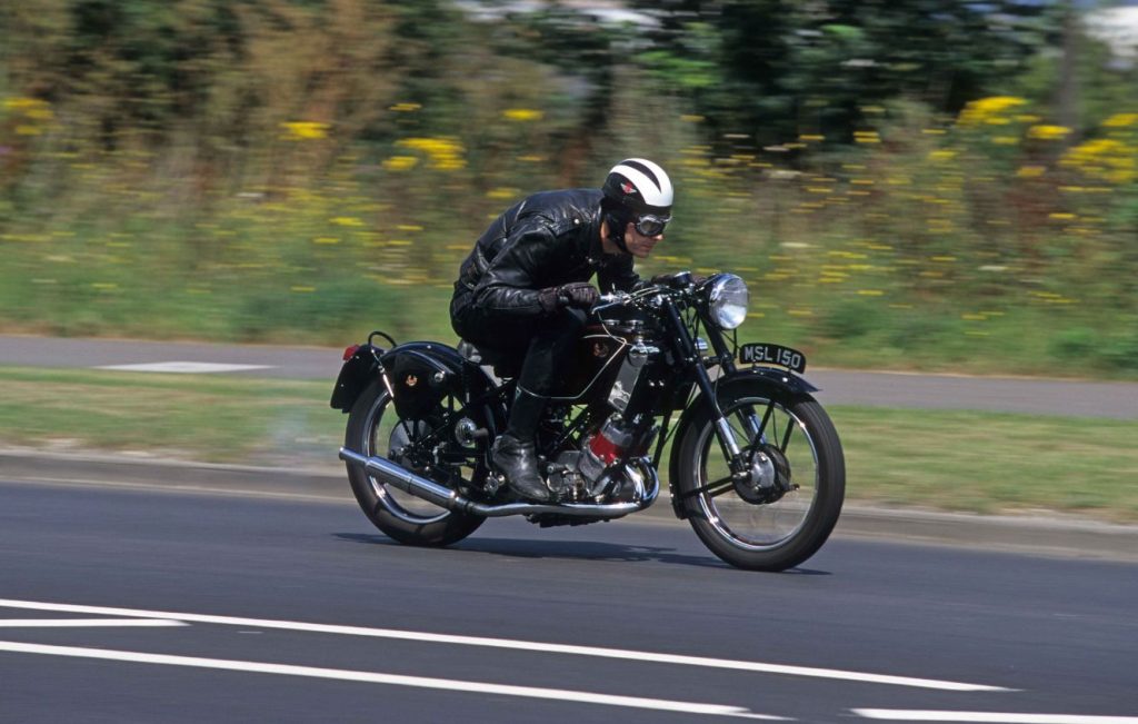 Man riding a Scott Flying Squirrel along a road at speed