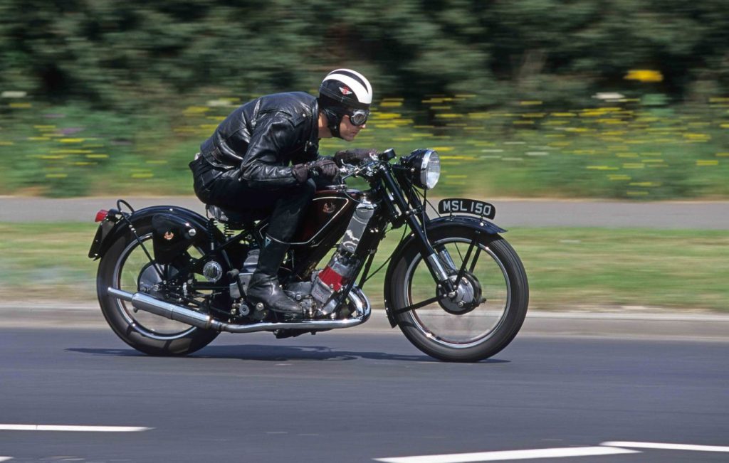 Man riding a Scott Flying Squirrel along a road at speed