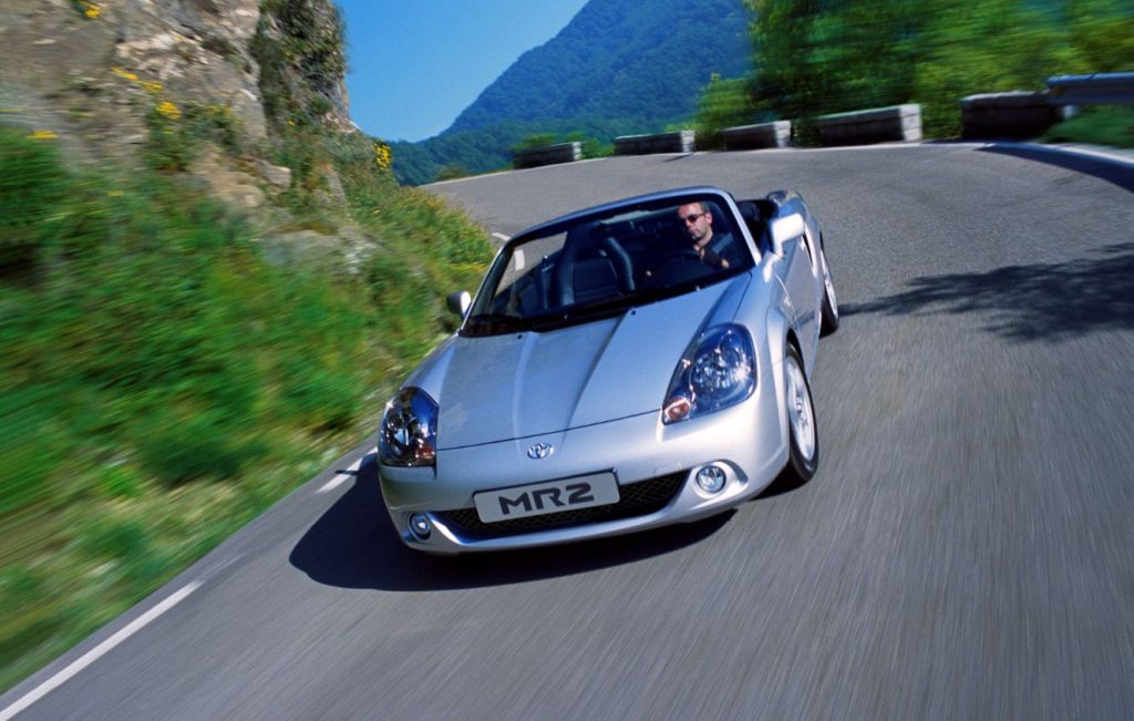 Man driving a silver Toyota MR2 MK3 along a country road