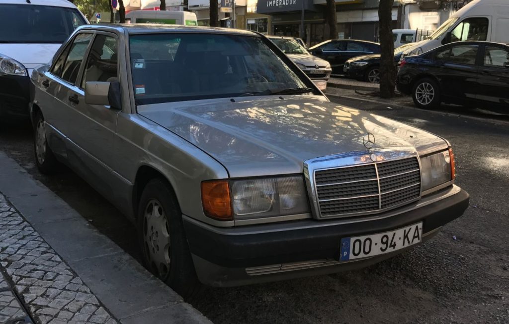A silver Mercedes-Benz W201 sedan parked on a street