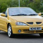 Yellow convertible Renault Megane with the roof off parked in a car park