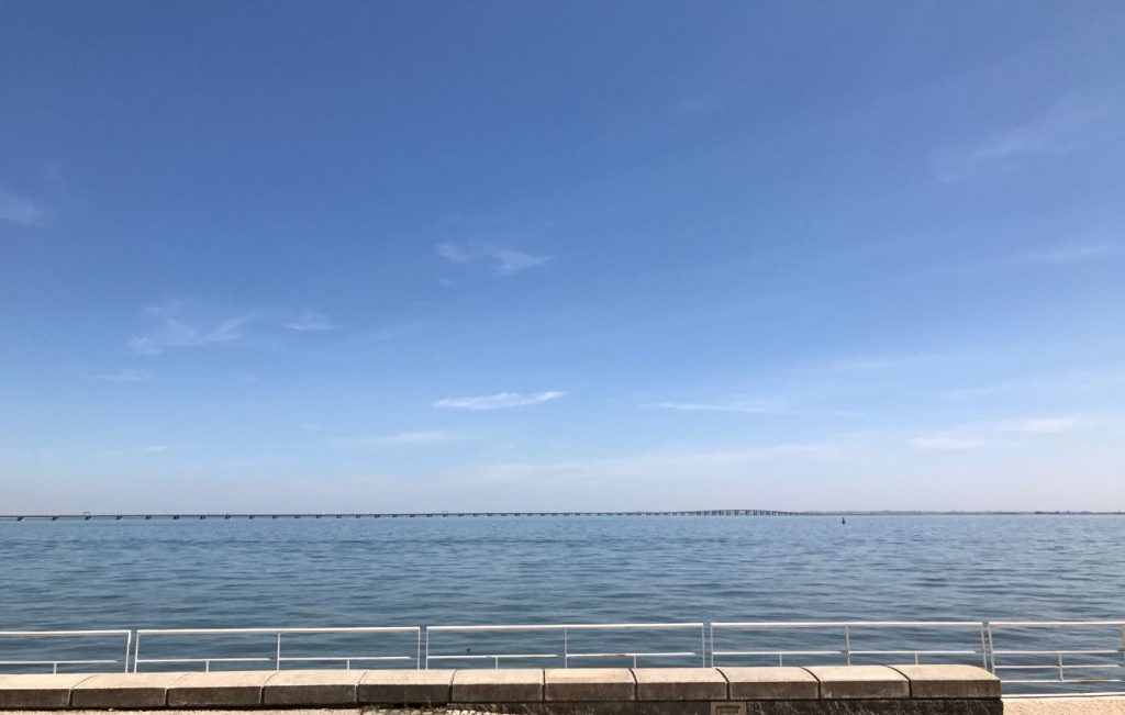 Promenade or boardwalk along a calm body of water on a blue skies day