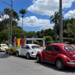 Four classic cars parked along a side street on a sunny day