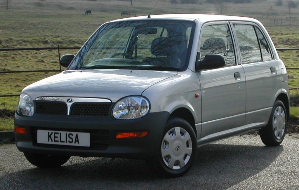 Silver Perodua Kelisa parked in front of a field