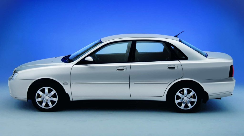 Side on view of a silver Proton Impian with blue backdrop