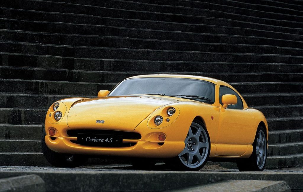 Yellow TVR Cerbera parked in front of concrete steps