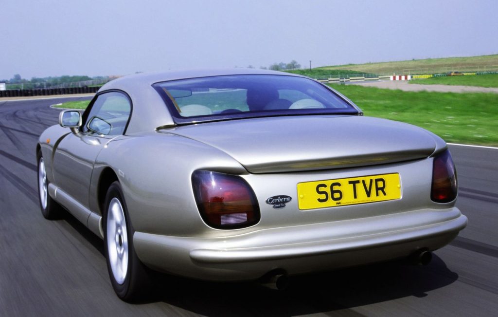 Rear view of a gold TVR classic car being driving along a race track