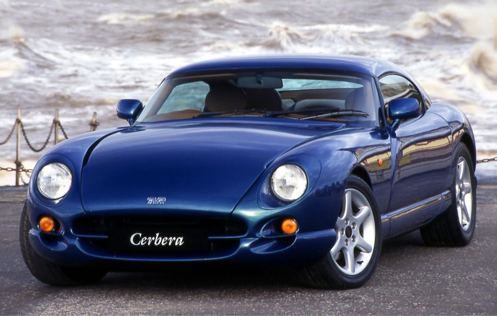 Metallic blue yellow TVR Cerbera parked in front of a wavy sea