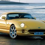 Yellow TVR Cerbera parked in front of the sea