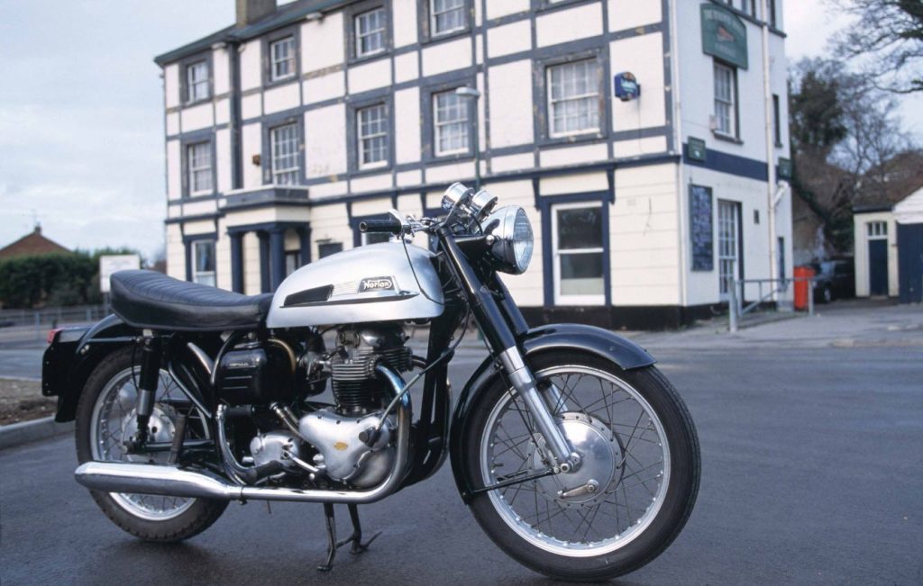 Norton Dominator 88 motorcycle parked outdoors, full right-side profile of restored classic British parallel twin