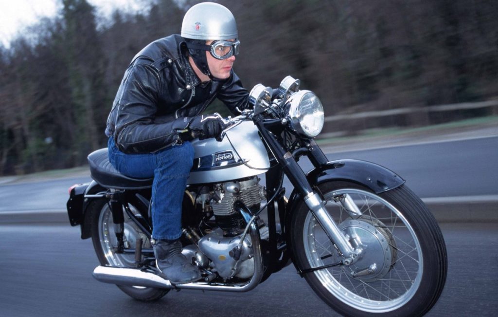 Man riding Norton Dominator 88 motorcycle along a road