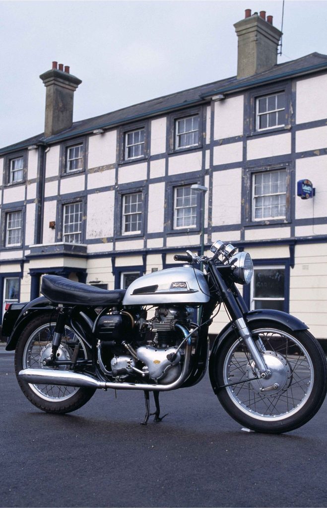 Norton Dominator 88 motorcycle parked outdoors, full right-side profile of restored classic British parallel twin