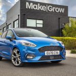 Blue Mk8 Ford Fiesta ST-Line five-door hatchback parked outside a modern black commercial building