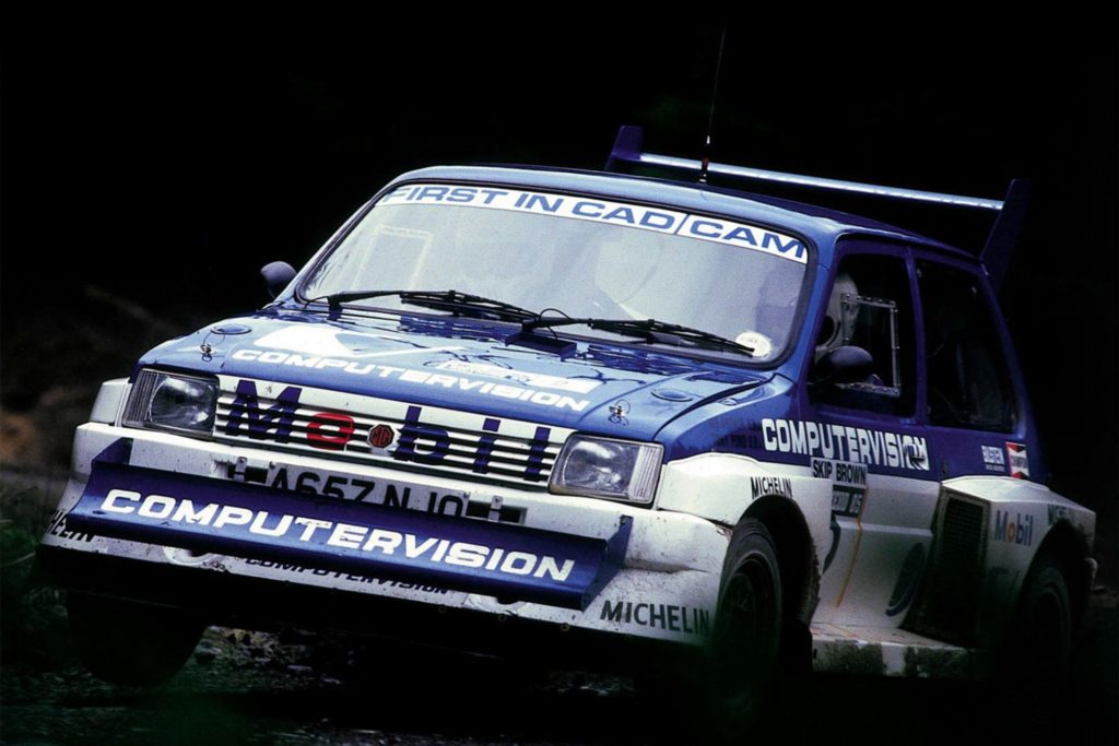 MG Metro 6R4 Group B rally car in blue Computervision livery airborne on a forest stage