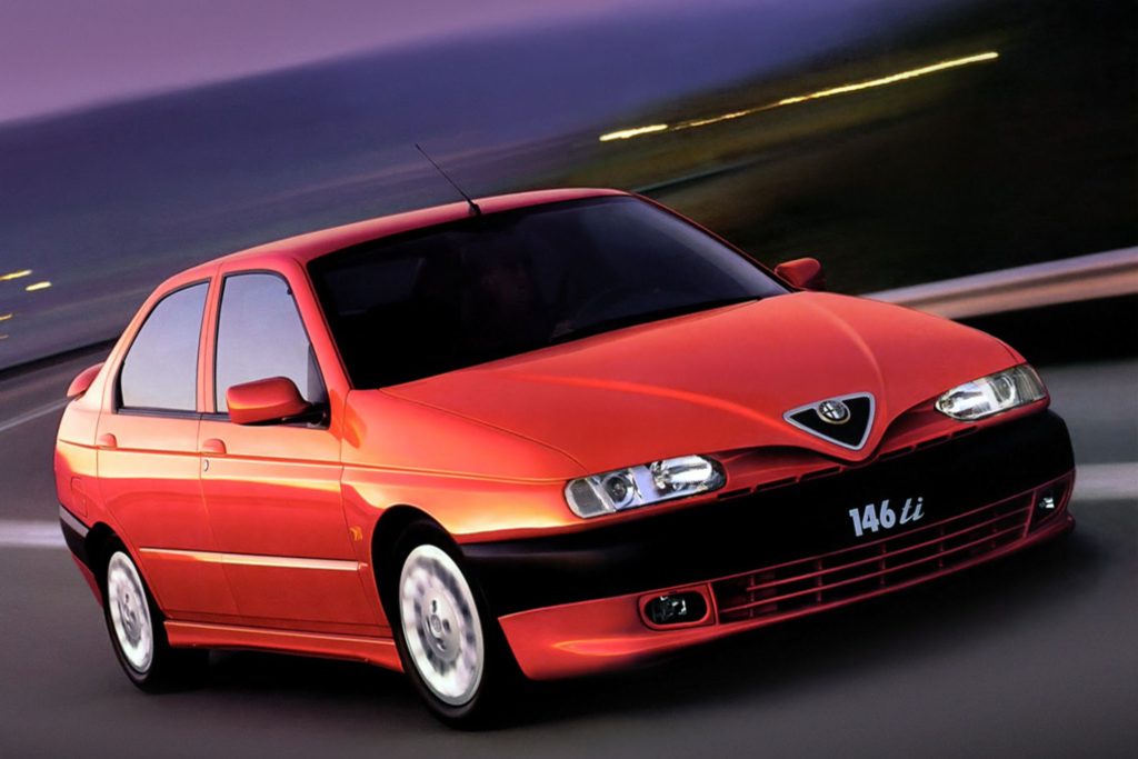 Red Alfa Romeo 146 Ti saloon photographed at speed against a blurred purple dusk background