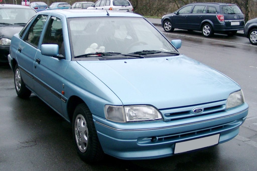 Light blue Mk5 Ford Escort five-door hatchback parked in a car park on a grey overcast day