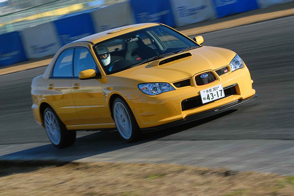 2006 Subaru Impreza WRX STI S204 RA-R in Lemon Yellow racing on track at Fuji Speedway Japan with helmet-wearing driver