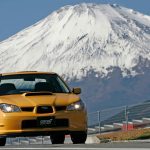 2006 Subaru Impreza WRX STI S204 RA-R Lemon Yellow front view parked at Fuji Speedway with snow-capped Mount Fuji in background