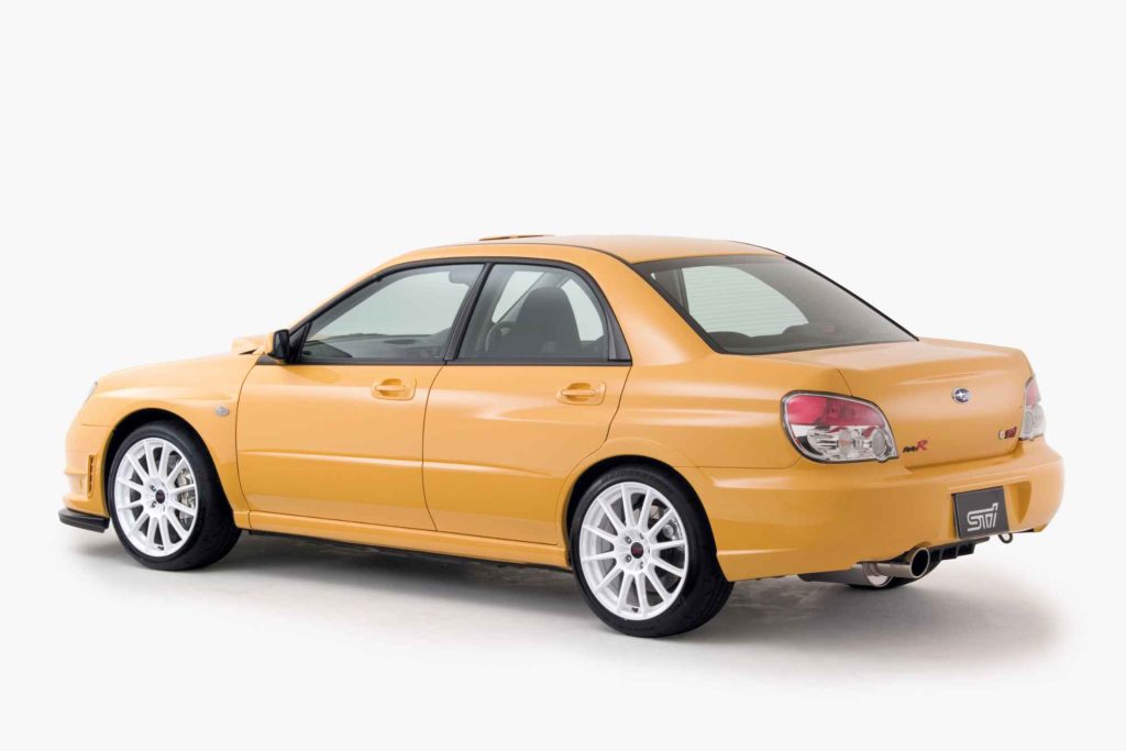 2006 Subaru Impreza WRX STI S204 RA-R Lemon Yellow rear three-quarter studio view showing RA-R badge center exit exhaust and white multi-spoke wheels