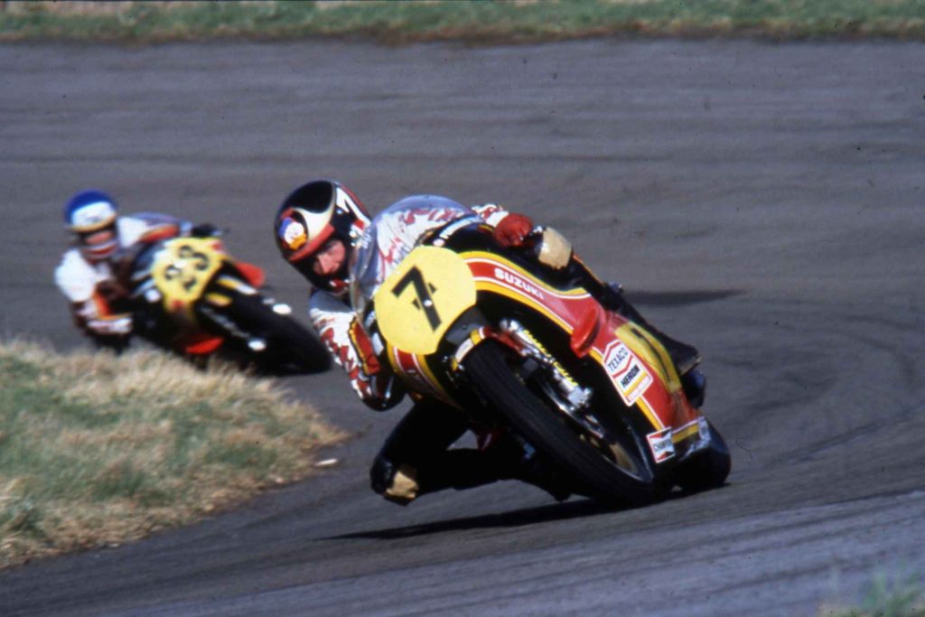 Barry Sheene leading on his yellow and black number 7 Suzuki, another rider close behind, both deeply committed through a fast corner