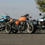Three iconic Italian superbikes of the 1970s lined up together: the Ducati 900SS in blue and silver, the Laverda Jota in orange, and the Moto Guzzi 850 Le Mans in pale blue