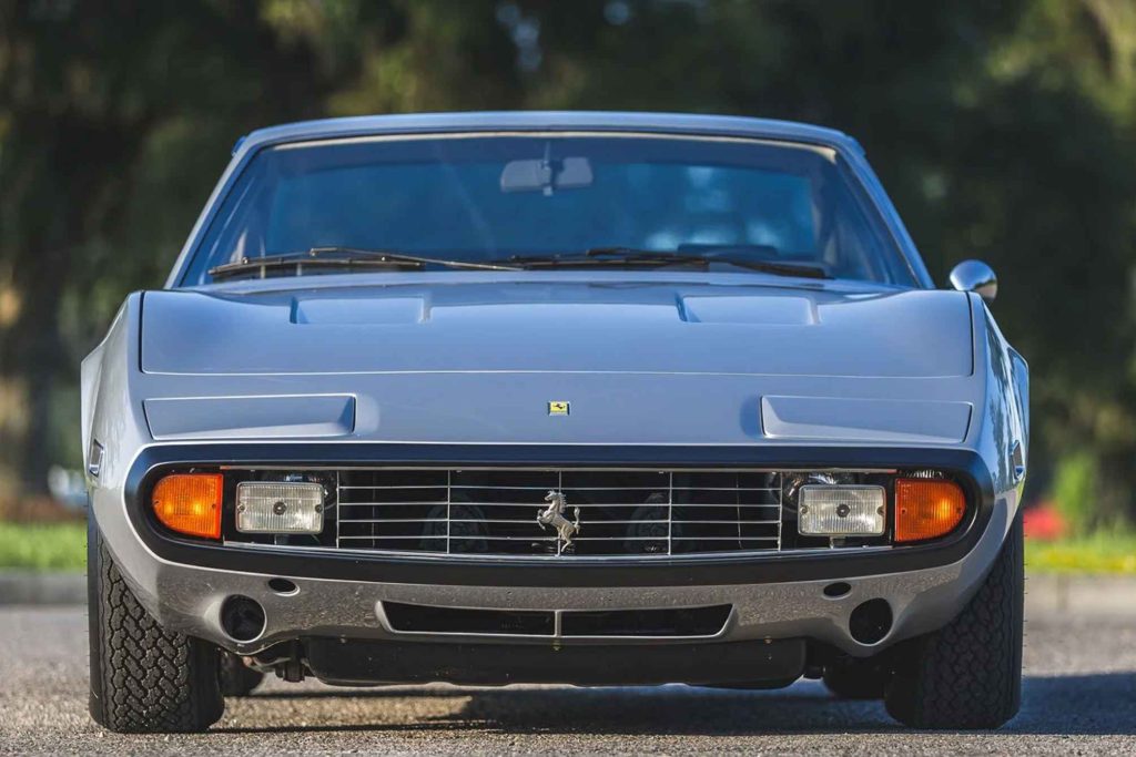 Ferrari 365 GTC/4 in silver-blue, straight-on front view showing the wide grille, prancing horse badge, rectangular headlights with amber turn signals, and flat hood with twin air intakes