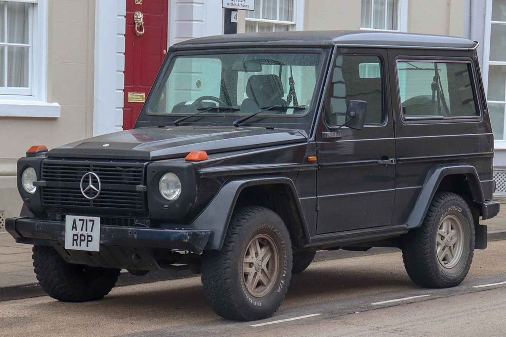 An early 1980s Mercedes-Benz 230GE G-Wagen in dark navy, parked on a UK street