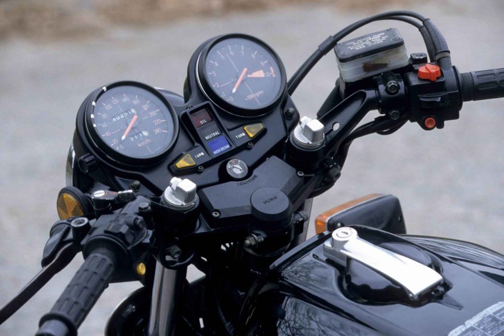 Honda CB900F instrument cluster showing a 240 km/h speedometer, tachometer redlined at 10,000 rpm, warning lights for oil, neutral, high beam, and turn signals, plus the central ignition switch.